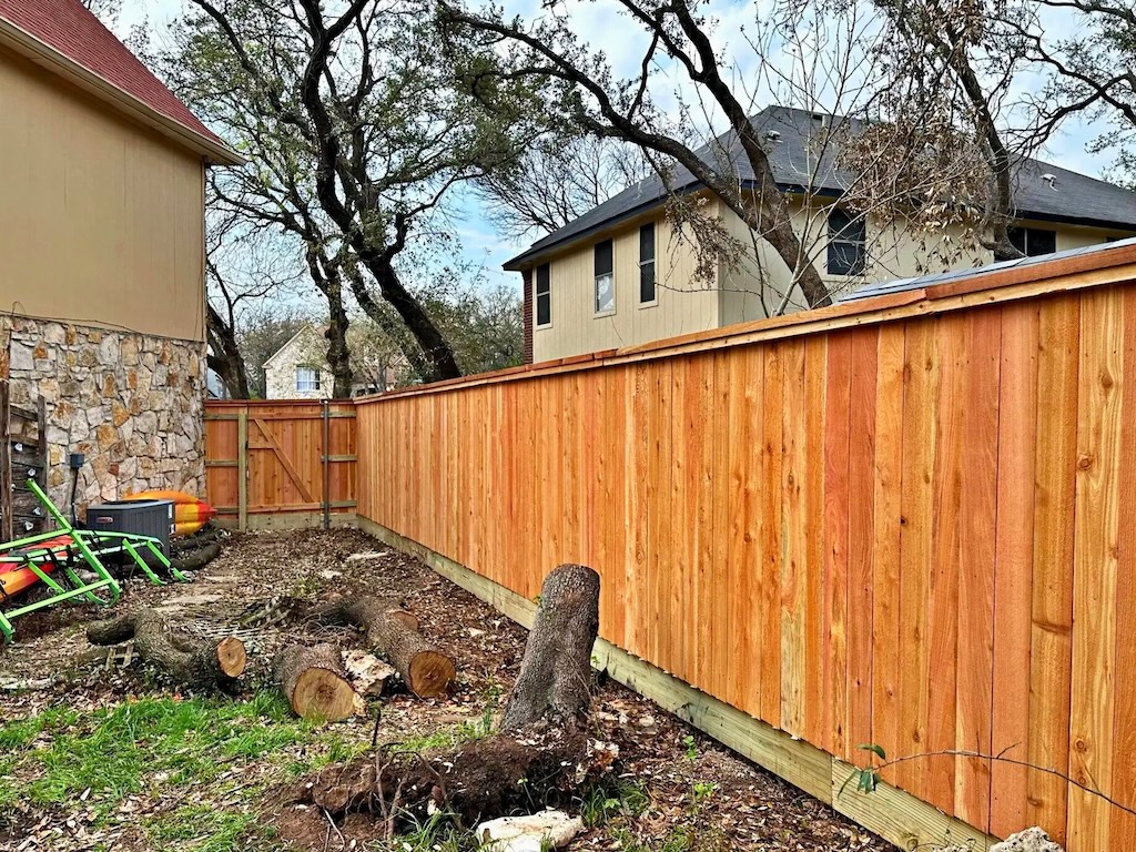 Freshly installed wooden privacy fence in a residential backyard
