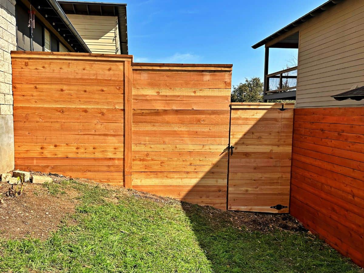Custom horizontal cedar privacy fence with matching wood gate installed
