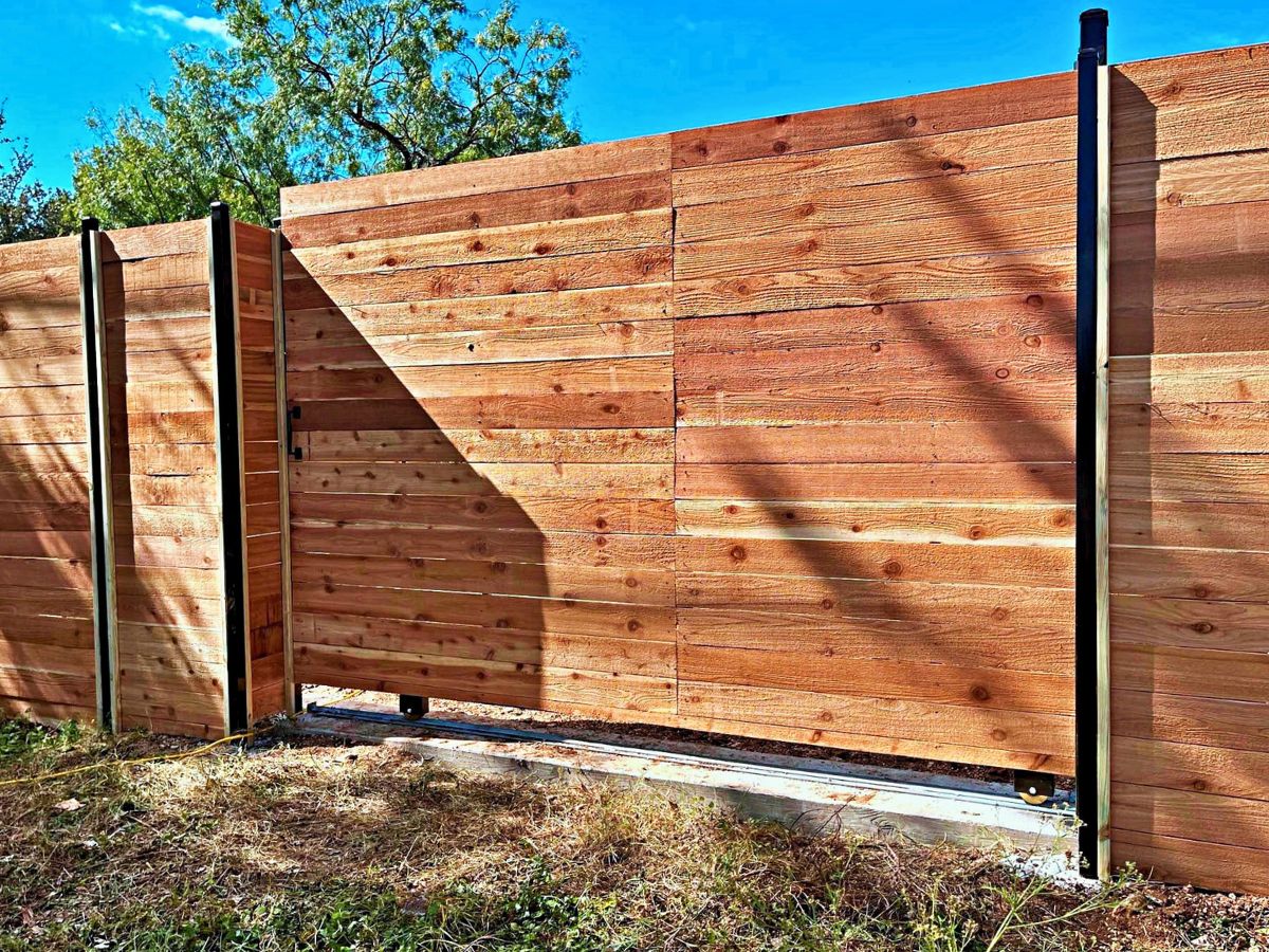 Wooden sliding gate with horizontal planks on a metal frame