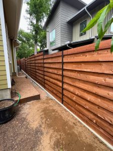 horizontal wood slatted privacy fence in modern backyard
