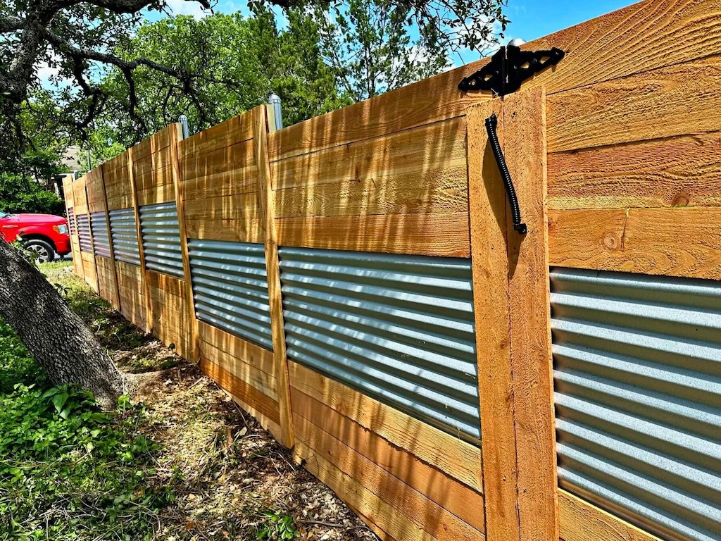 Modern wood fence replacement featuring corrugated metal panels for added durability
